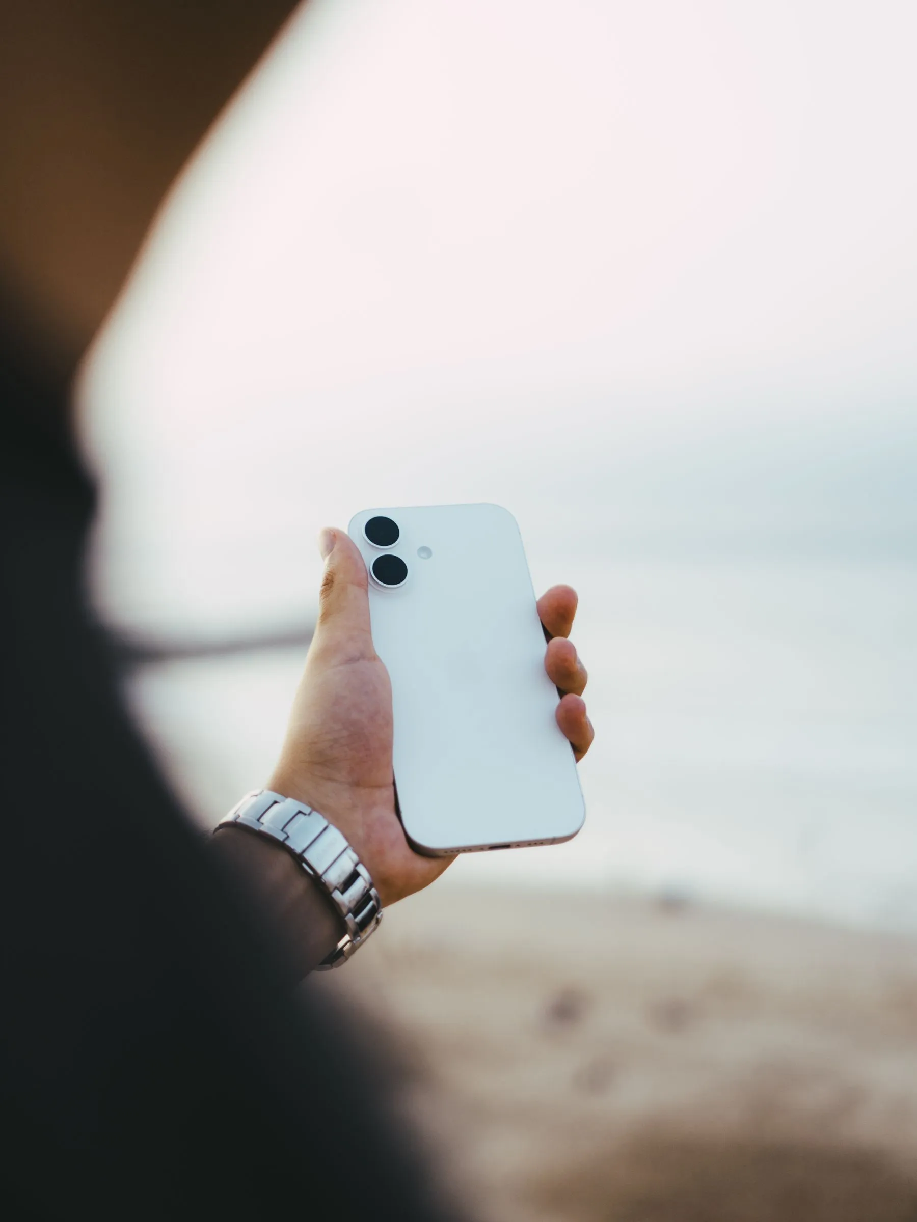 Une personne tient un smartphone au bord de la mer à Rabat